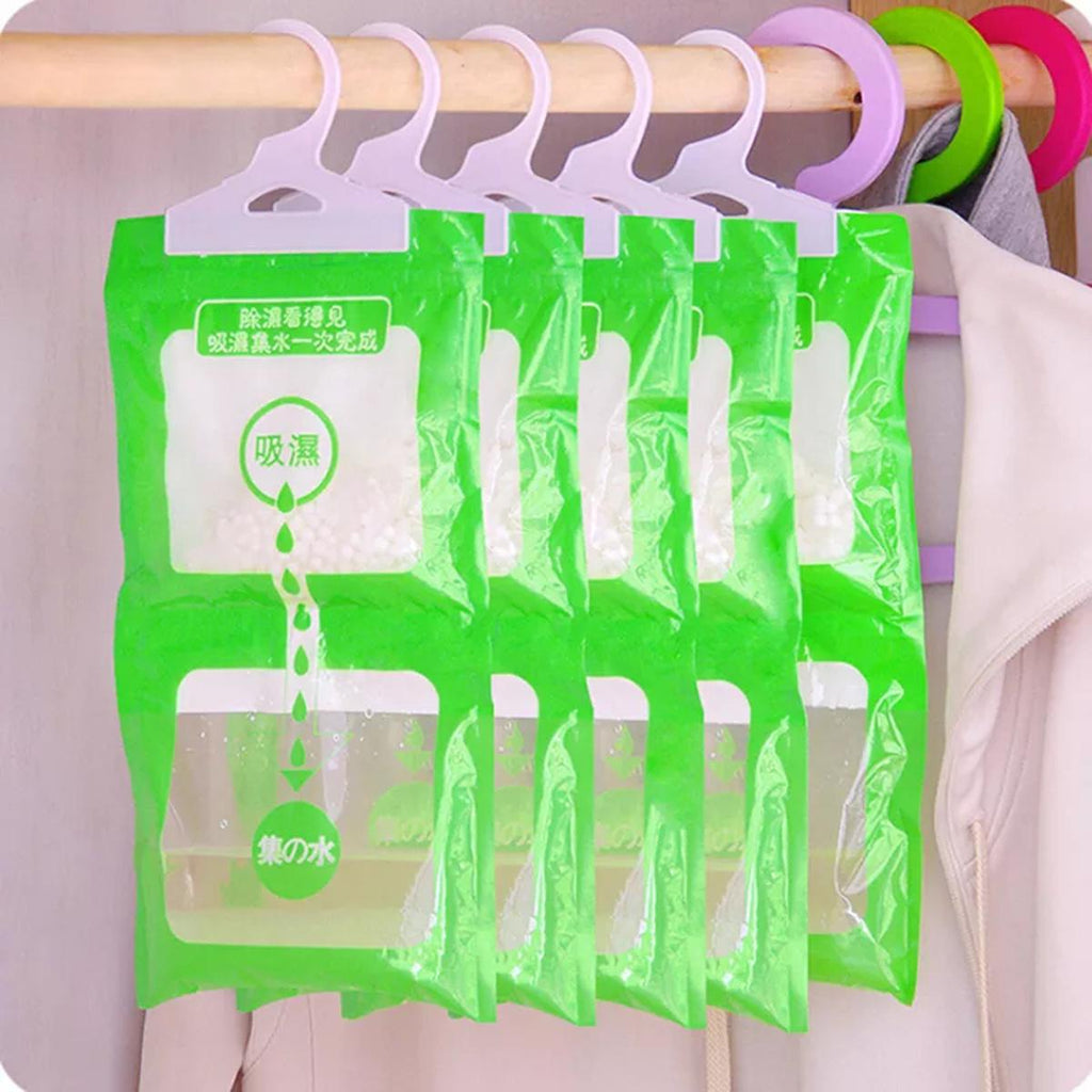 Hanging moisture absorber bag with clear lower chamber showing collected water, hung on a wardrobe rail